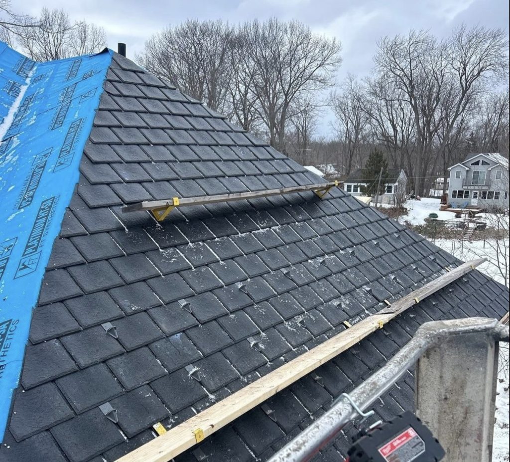 New shingle roof ridge with synthetic underlayment partly installed