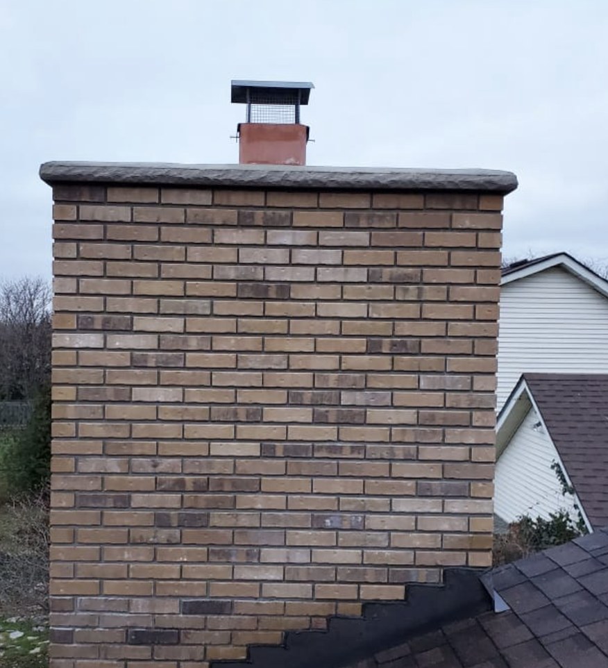 Rebuilt brick chimney with a stone crown and new chimney cap