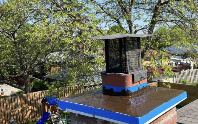 Brick chimney crown with a fresh waterproof coating and new chimney cap