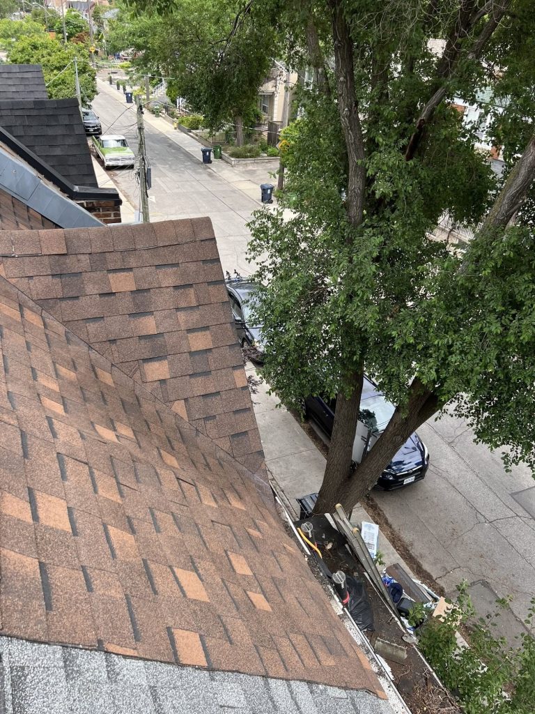 Brown asphalt shingle roof with hip and valley, finished over a Toronto street